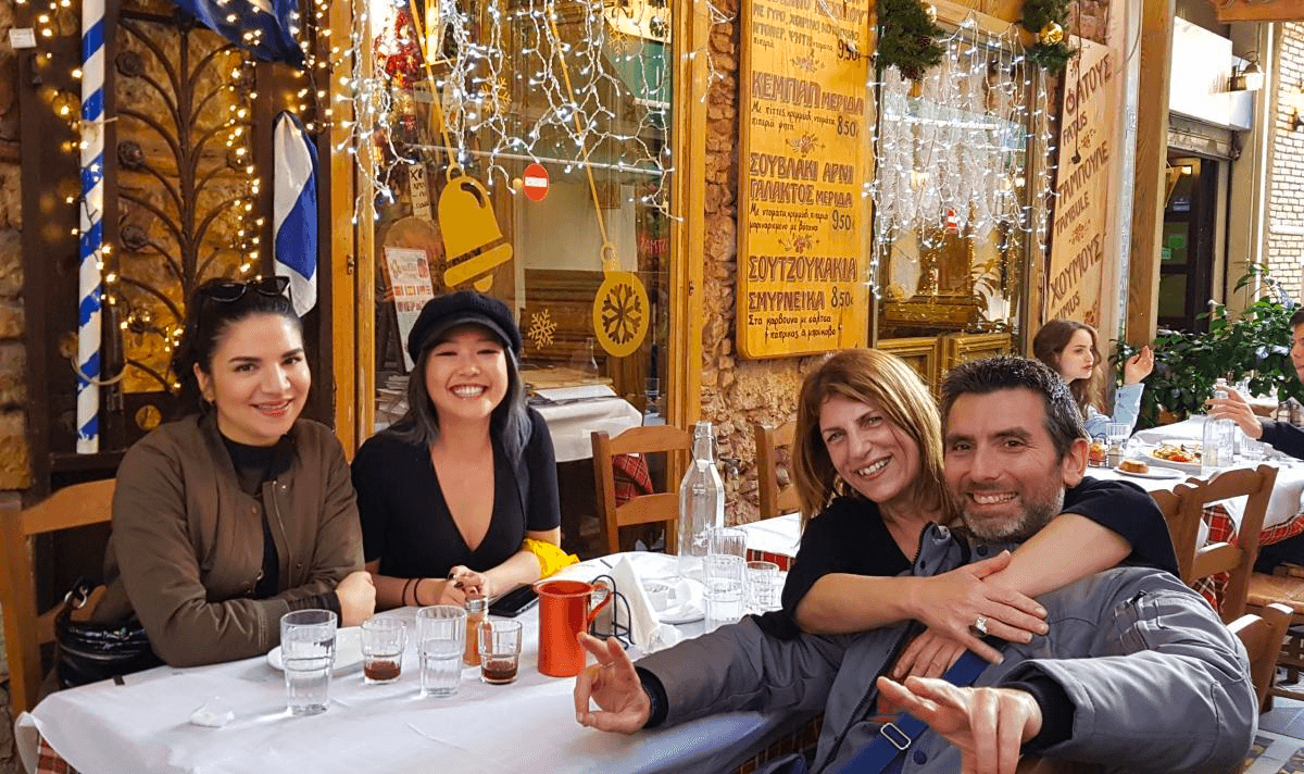 Group dining at outdoor Athens taverna, enjoying local meze