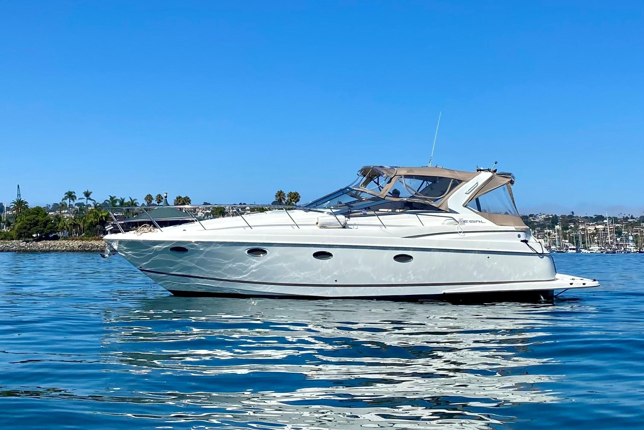 Luxury motor yacht cruising calm coastal waters under blue sky