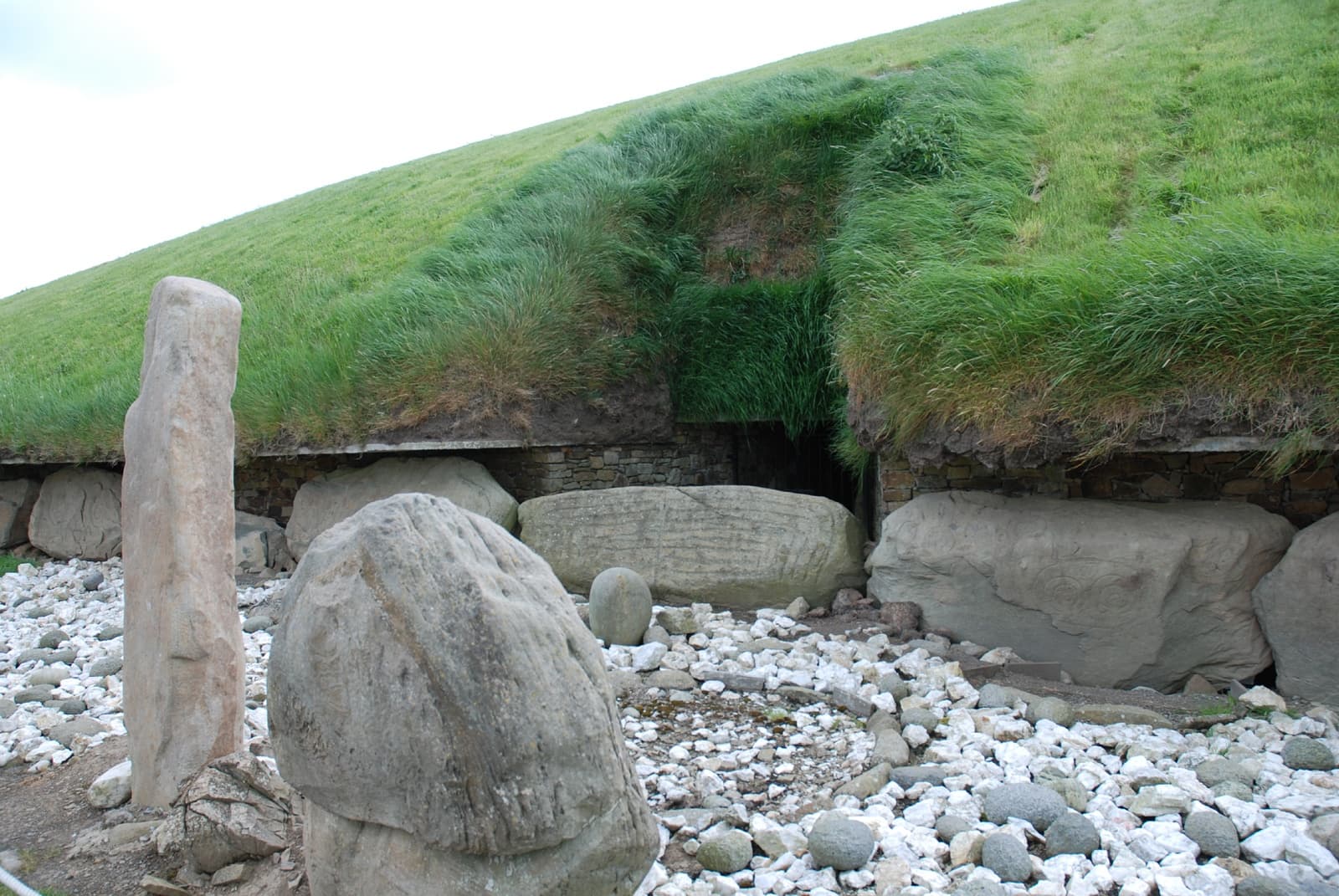 Coastal standing stones guarding burial chamber on stony beach