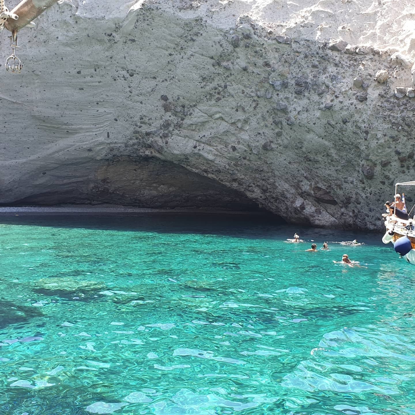 Swimmers exploring sea cave in turquoise Mediterranean waters