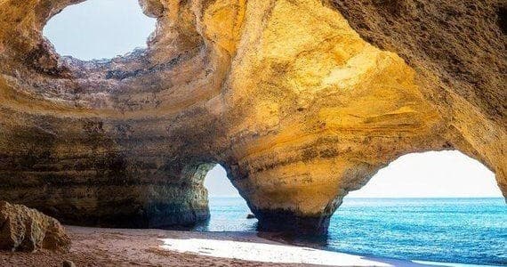 Sea cave arch near Lagos, Portugal with sunlit ocean entrance