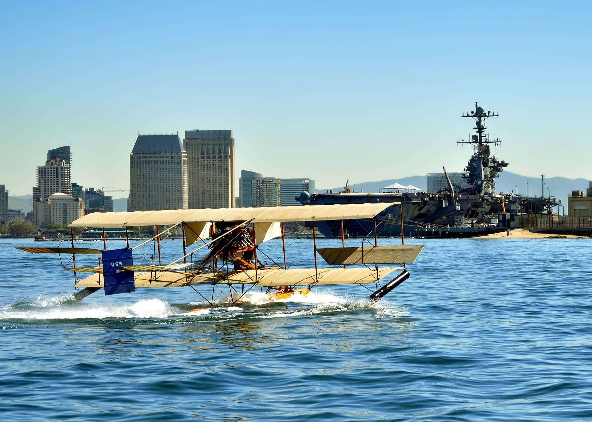 Seaplane taking off over harbor with city skyline in background