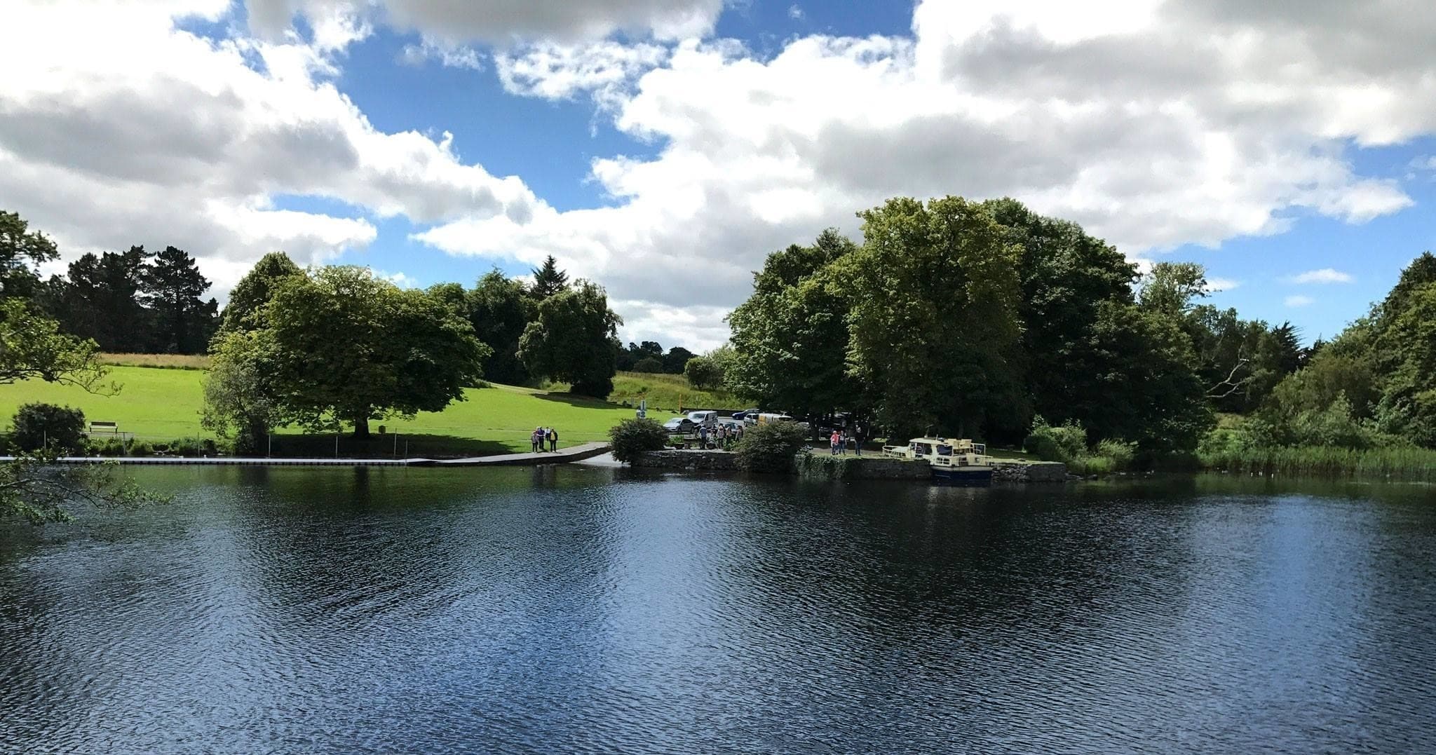 Tranquil lakeside park with moored boat and scenic water view