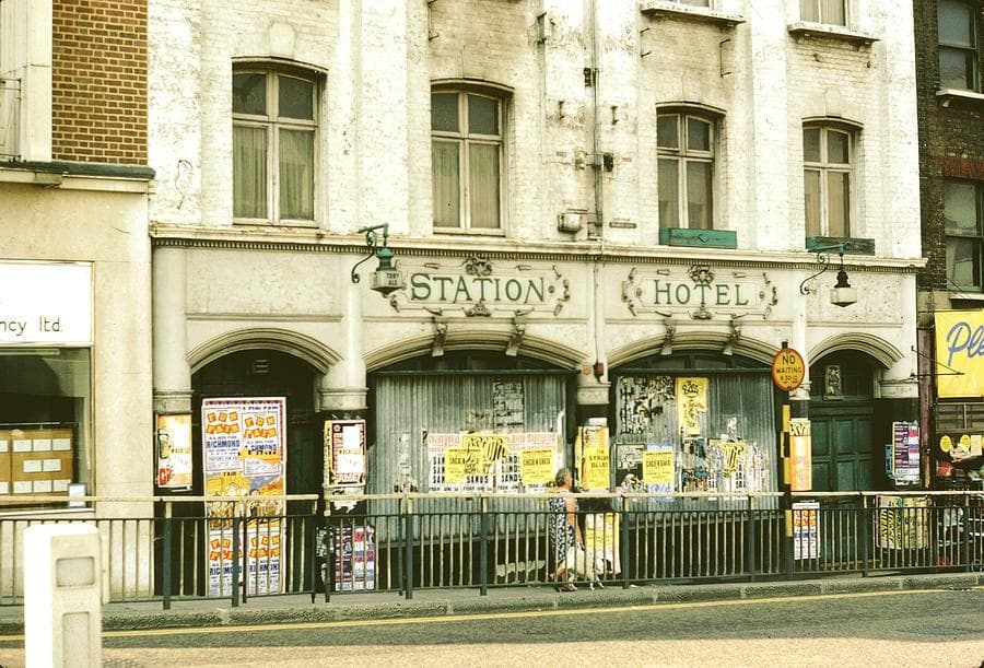 Historic Station Hotel facade on busy urban street, storefronts