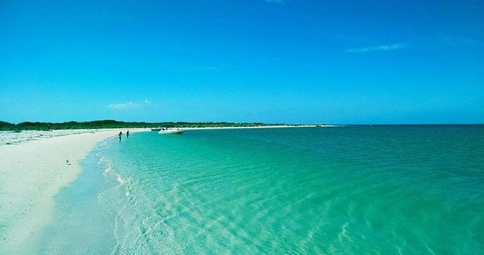 Pristine turquoise beach and shallow waters on tropical island