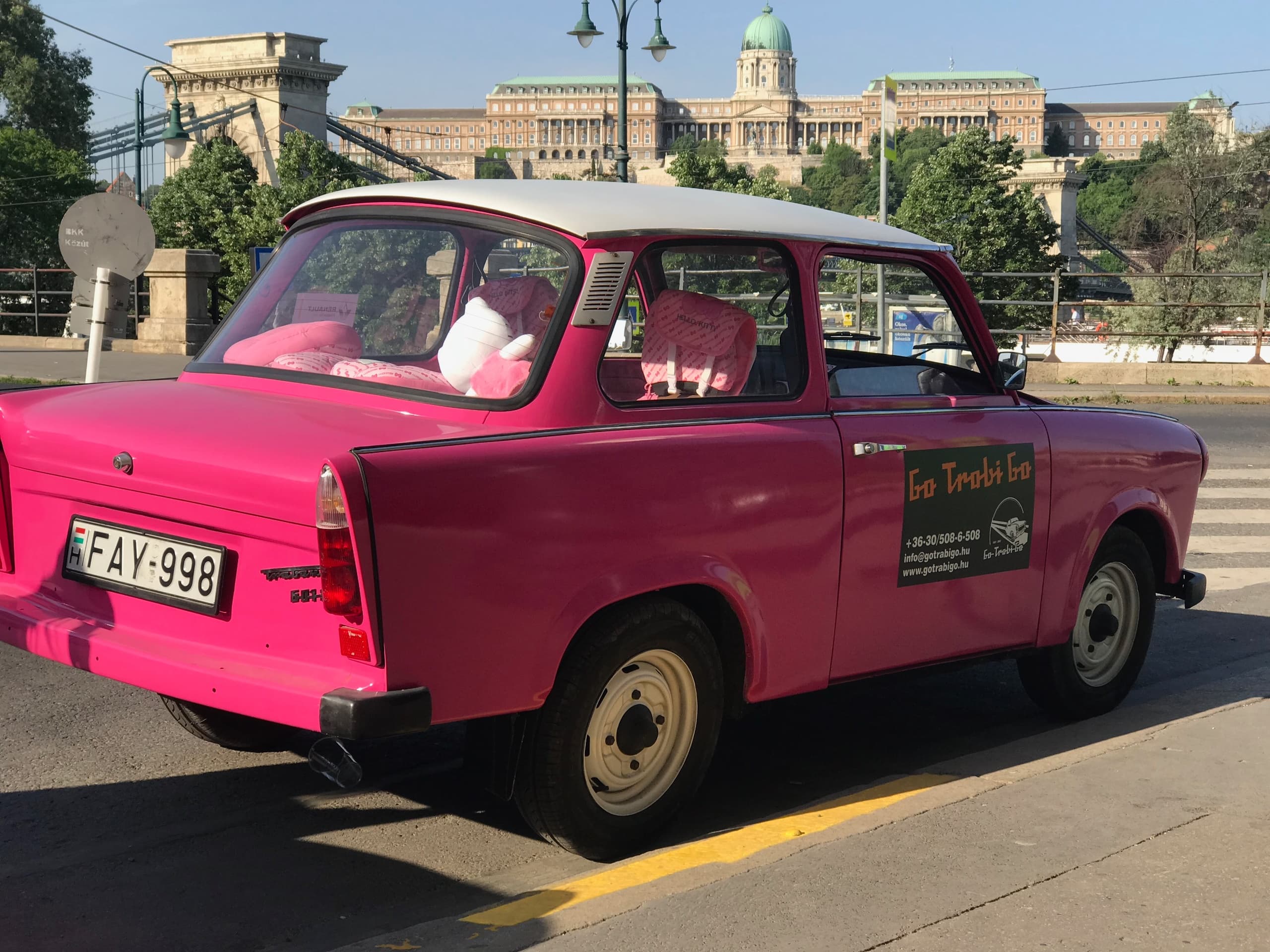 Pink vintage Trabant taxi parked on a sunny Budapest street