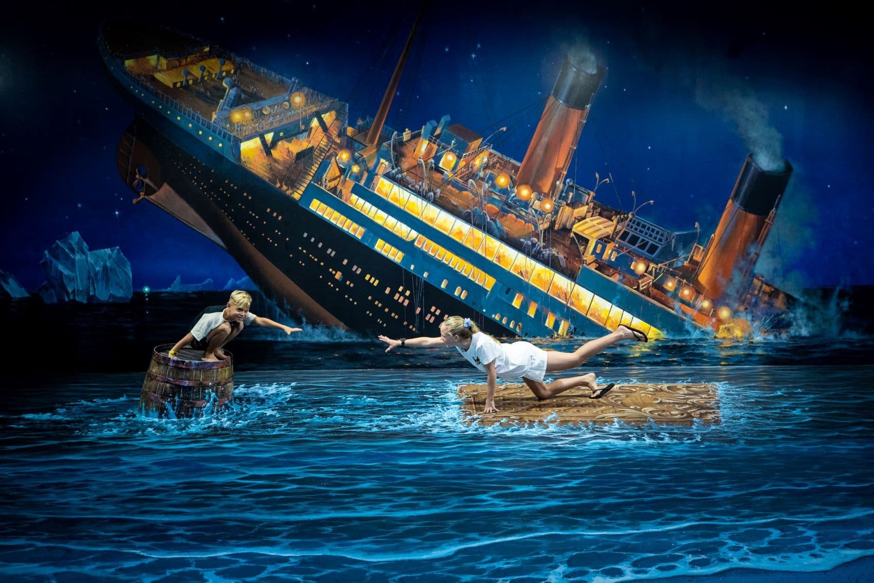 Passengers clinging to debris near sinking ocean liner at night