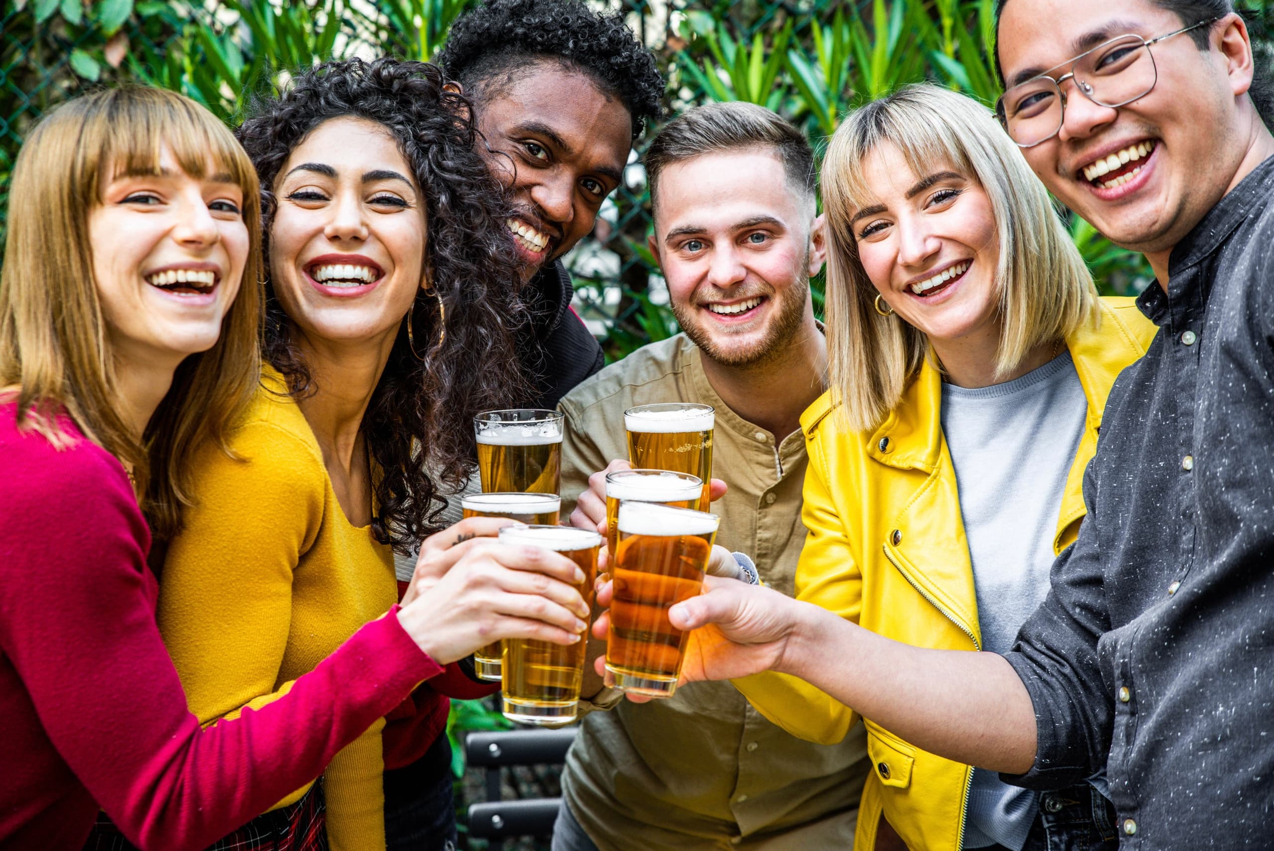 Group toasting beers on an indoor tasting tour, lively social