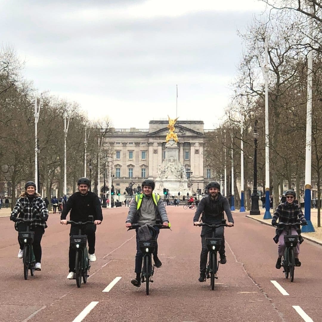 Group cycling down The Mall toward Buckingham Palace, London