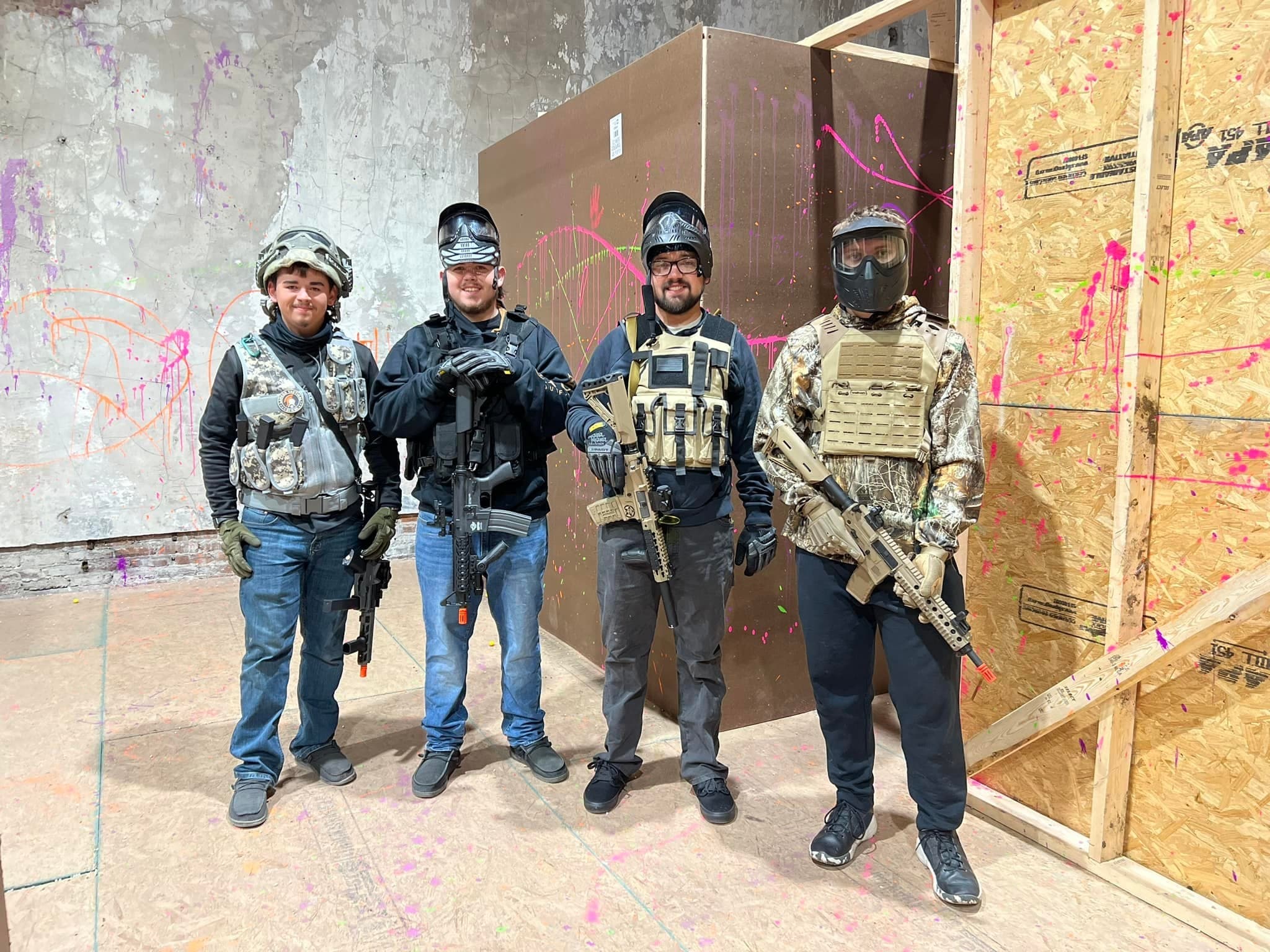 Players in tactical gear at indoor airsoft/paintball arena