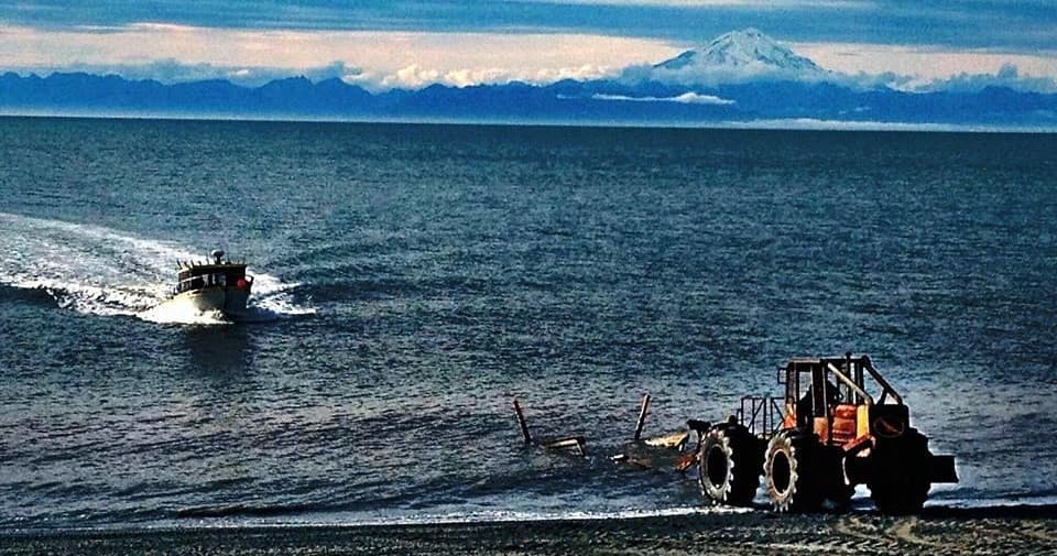 Fishing boat cruising coastal waters with distant snowy mountains