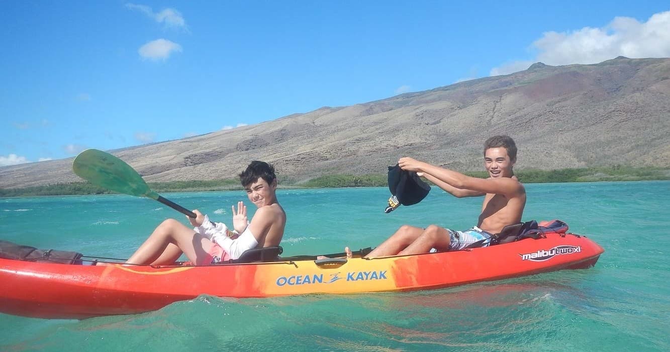 Two kayakers paddling clear lagoon near Molokai coast