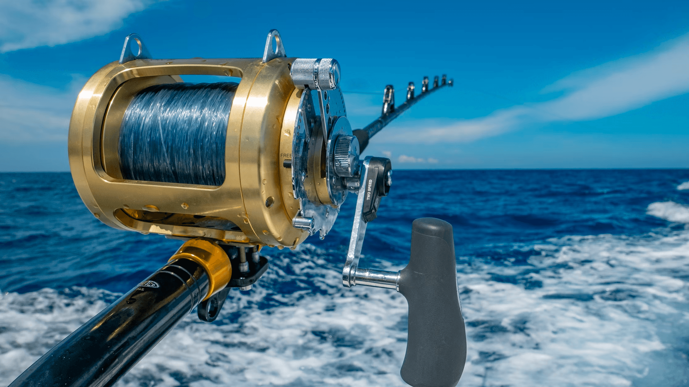 Deep-sea fishing reel over open ocean waves while trolling