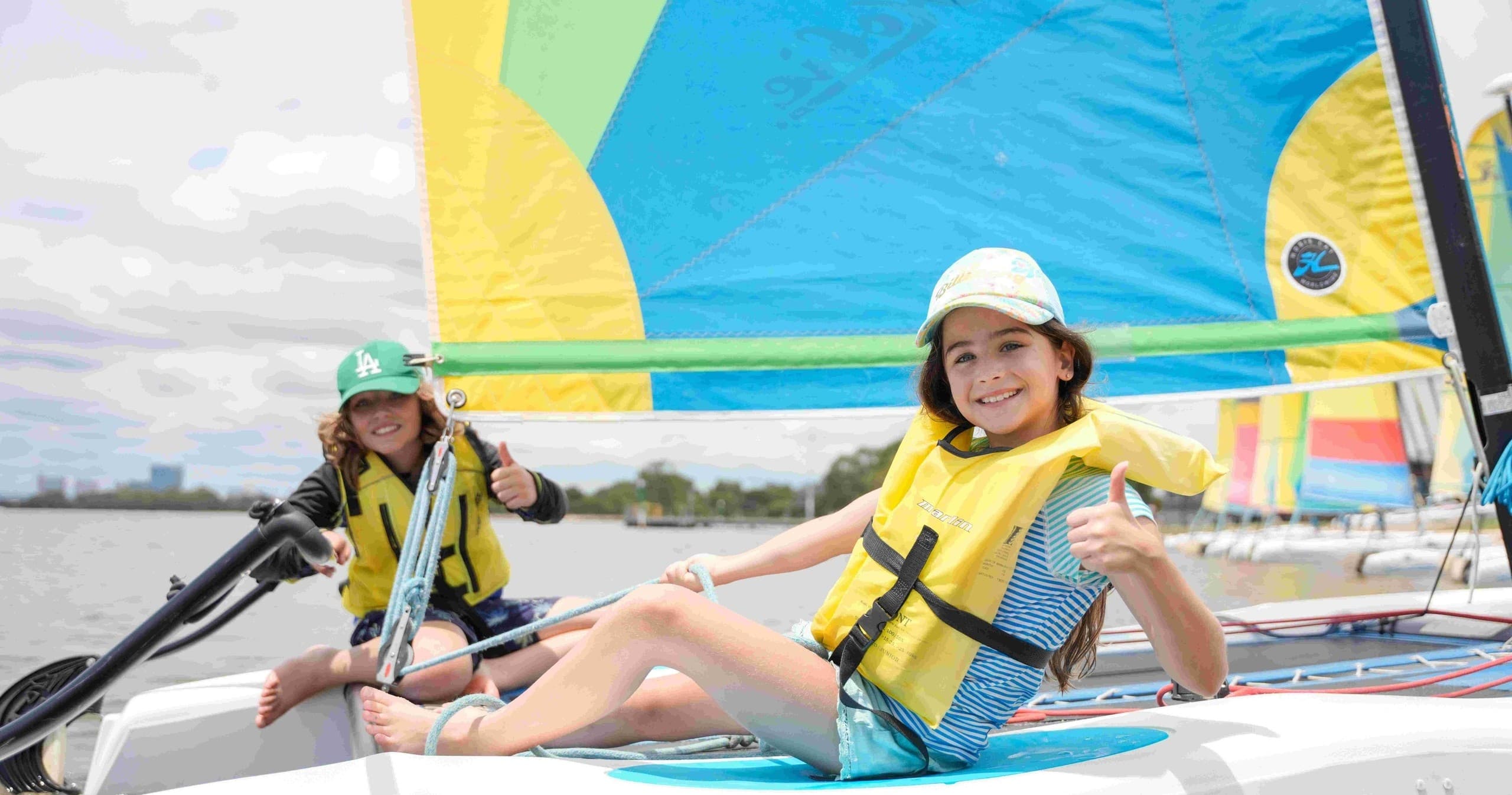 Kids enjoying beginner sailing on colorful catamaran