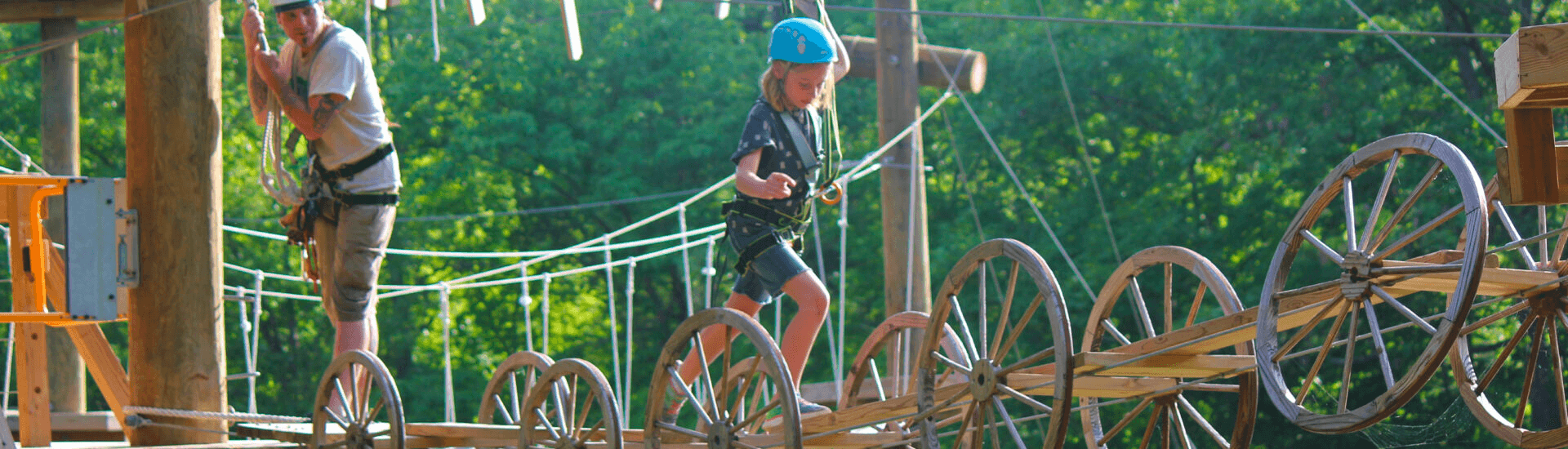 Participants on elevated ropes course/zipline platform in woods