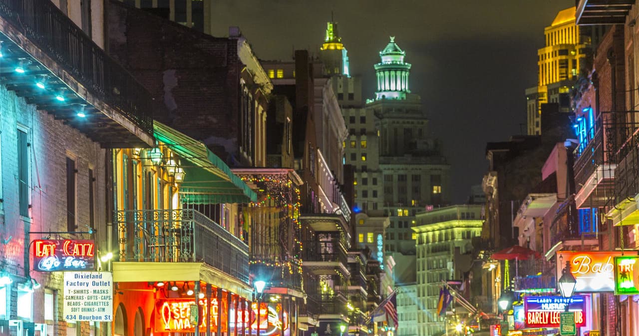 Nighttime Bourbon Street neon-lit nightlife on New Orleans street