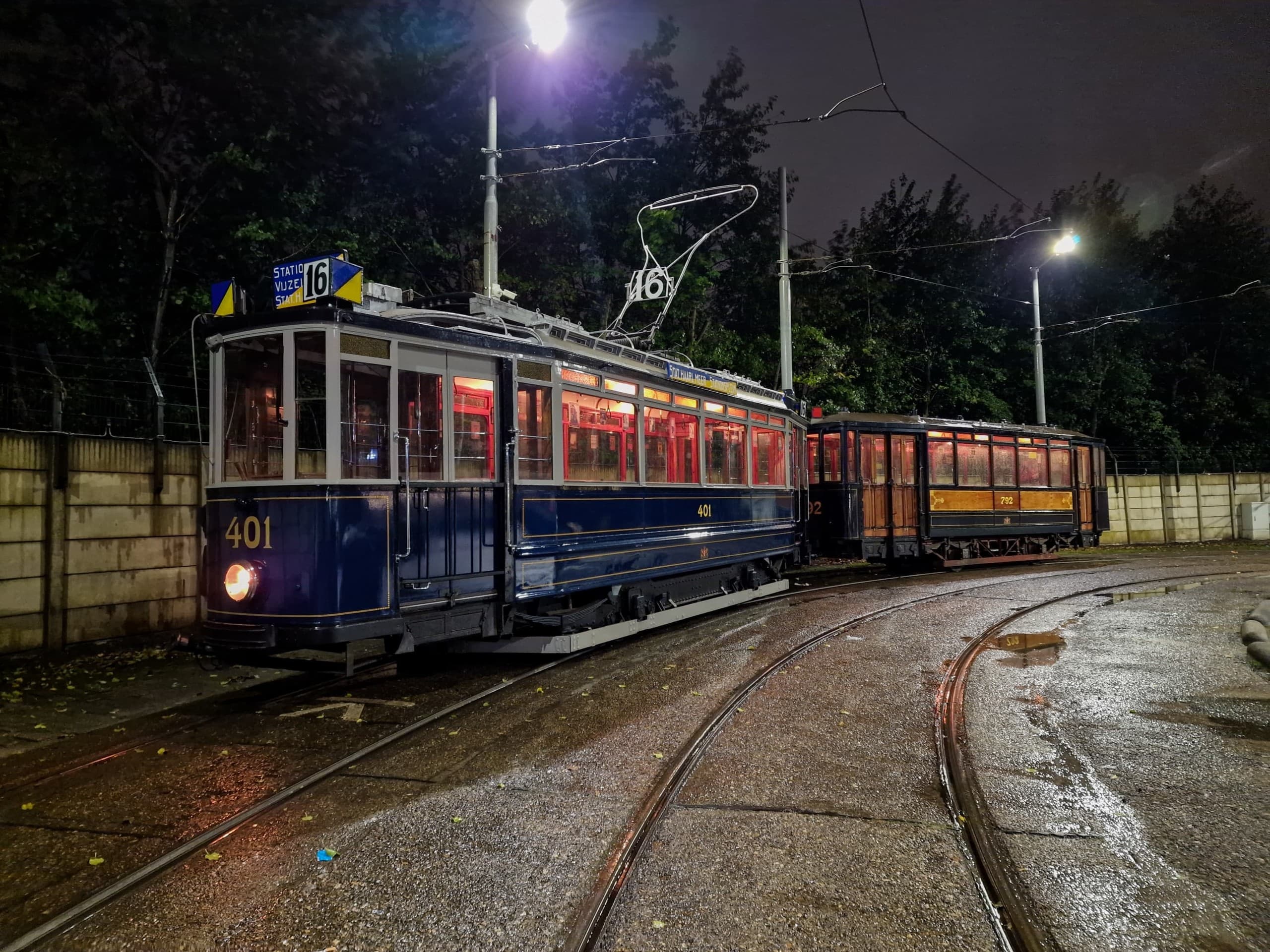 Nighttime tram on curved wet tracks, dramatic urban rail scene