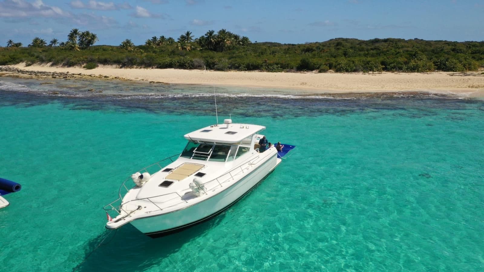 Luxury yacht anchored in shallow turquoise sandbar waters