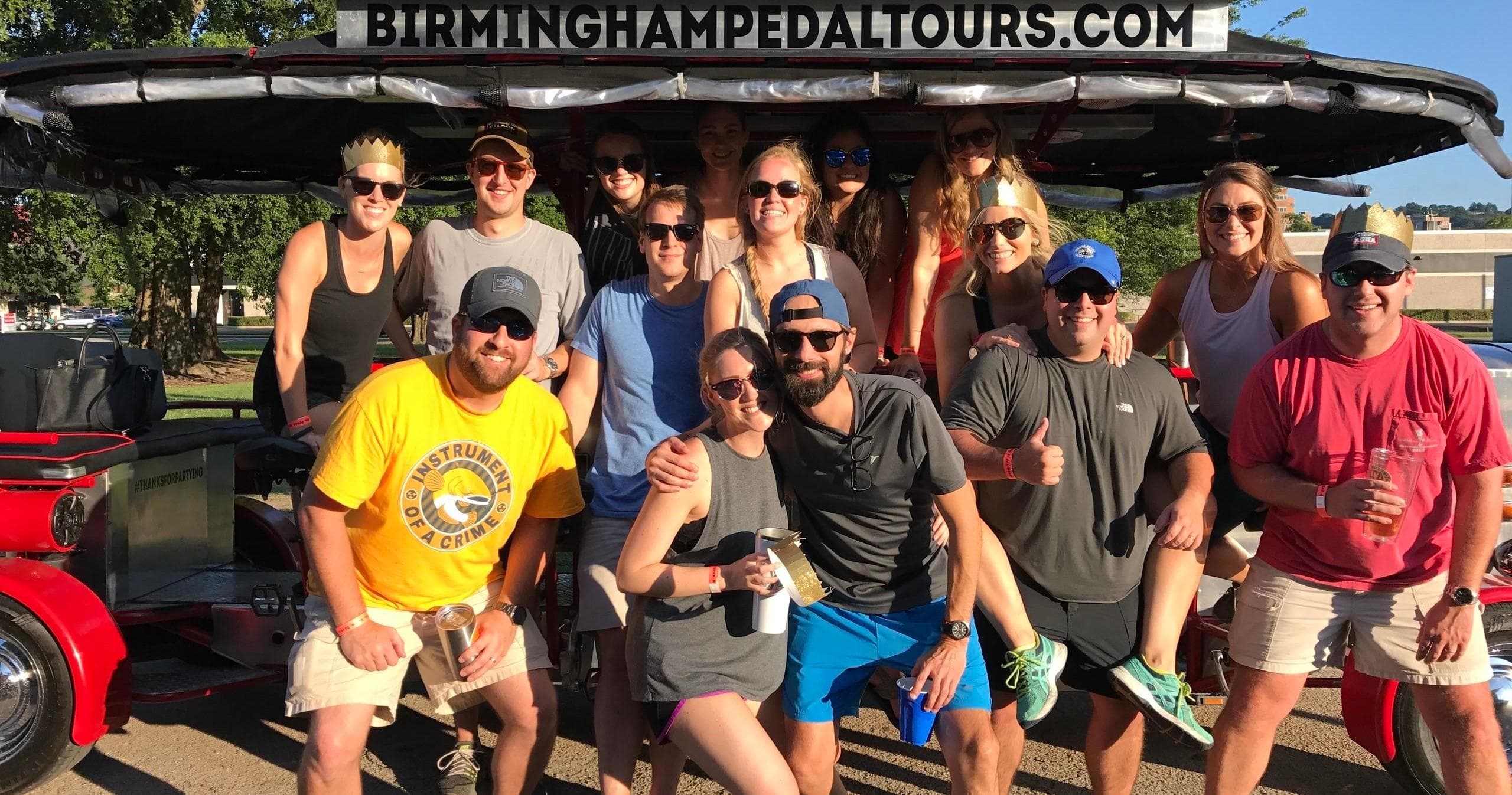 Group posing with Birmingham pedal tour vehicle outside venue