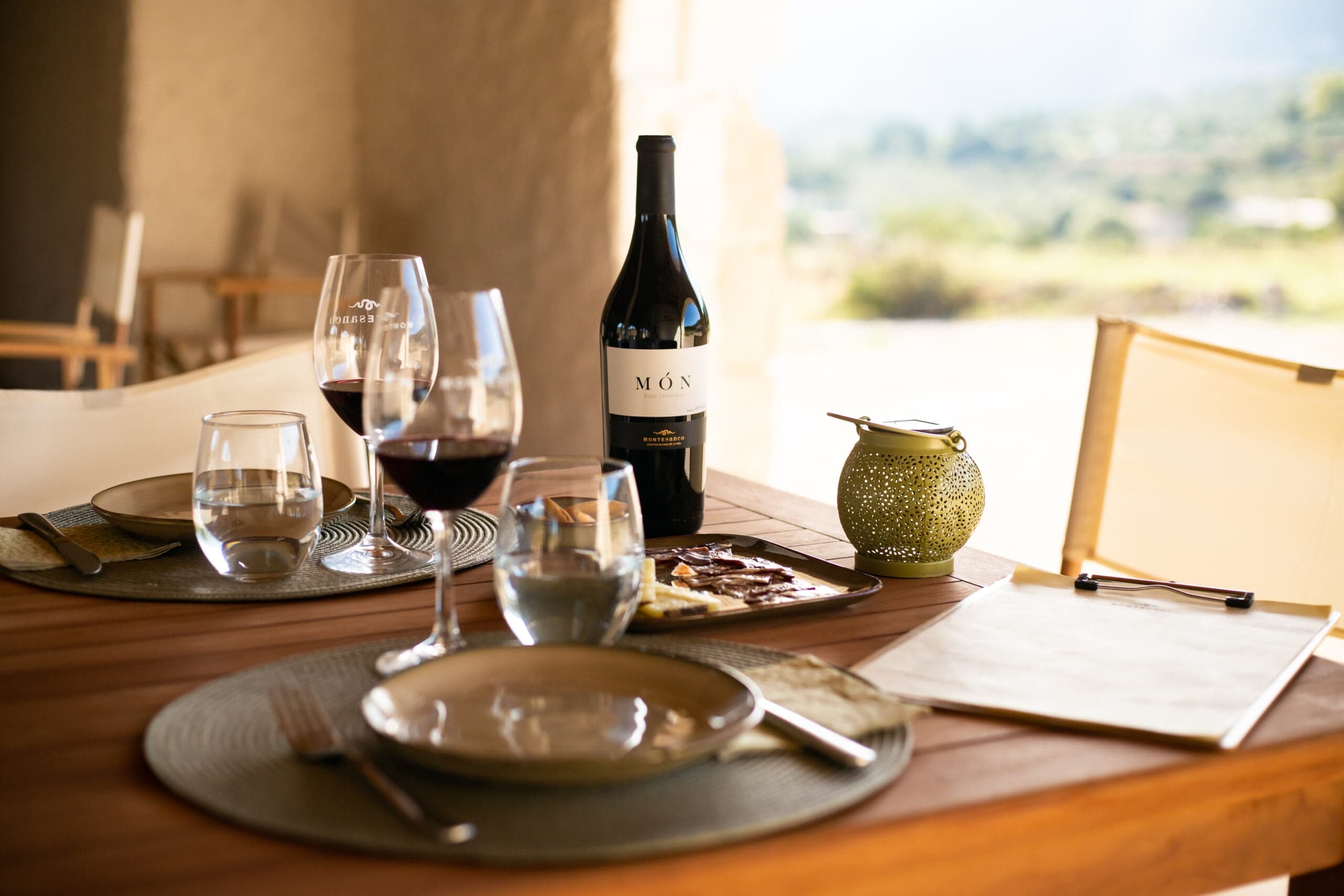 Sunlit indoor wine tasting table set with glasses and bottles