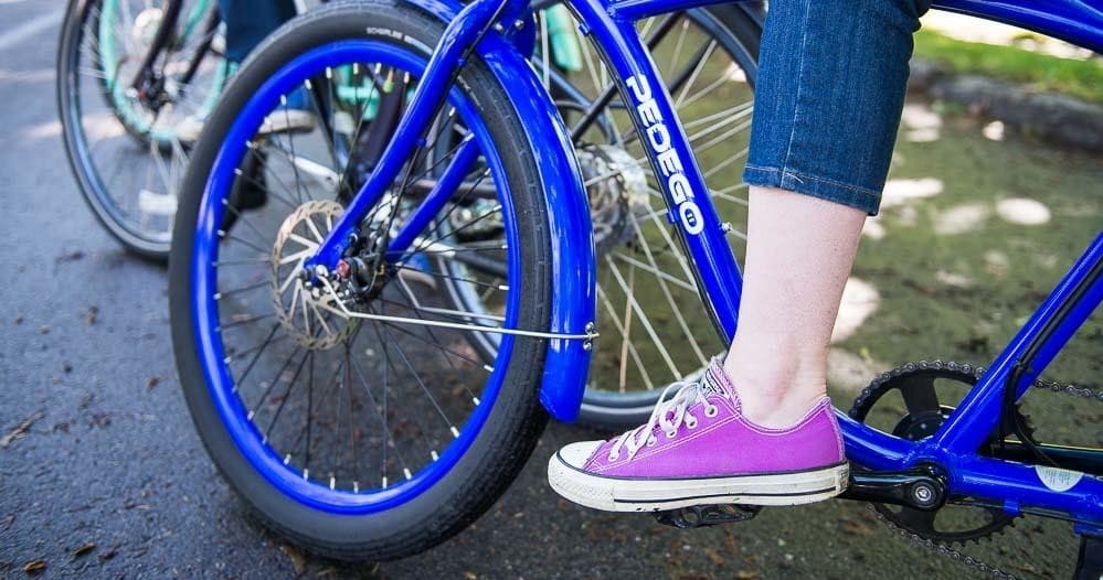 Close-up of electric bike wheel and foot on pedal in park
