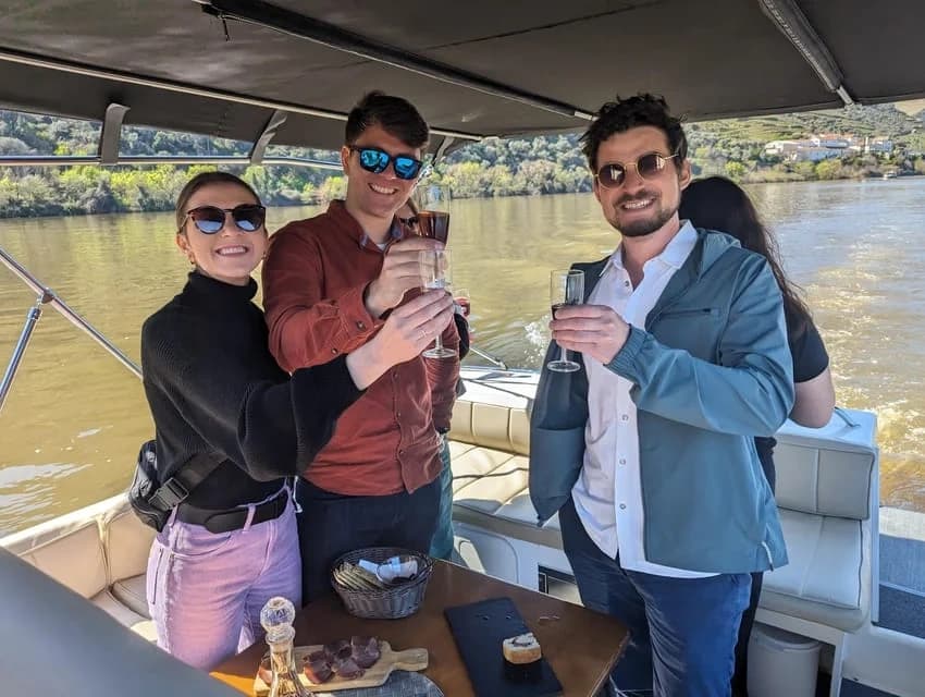 Friends toasting on river boat cruise through Douro Valley vineyards