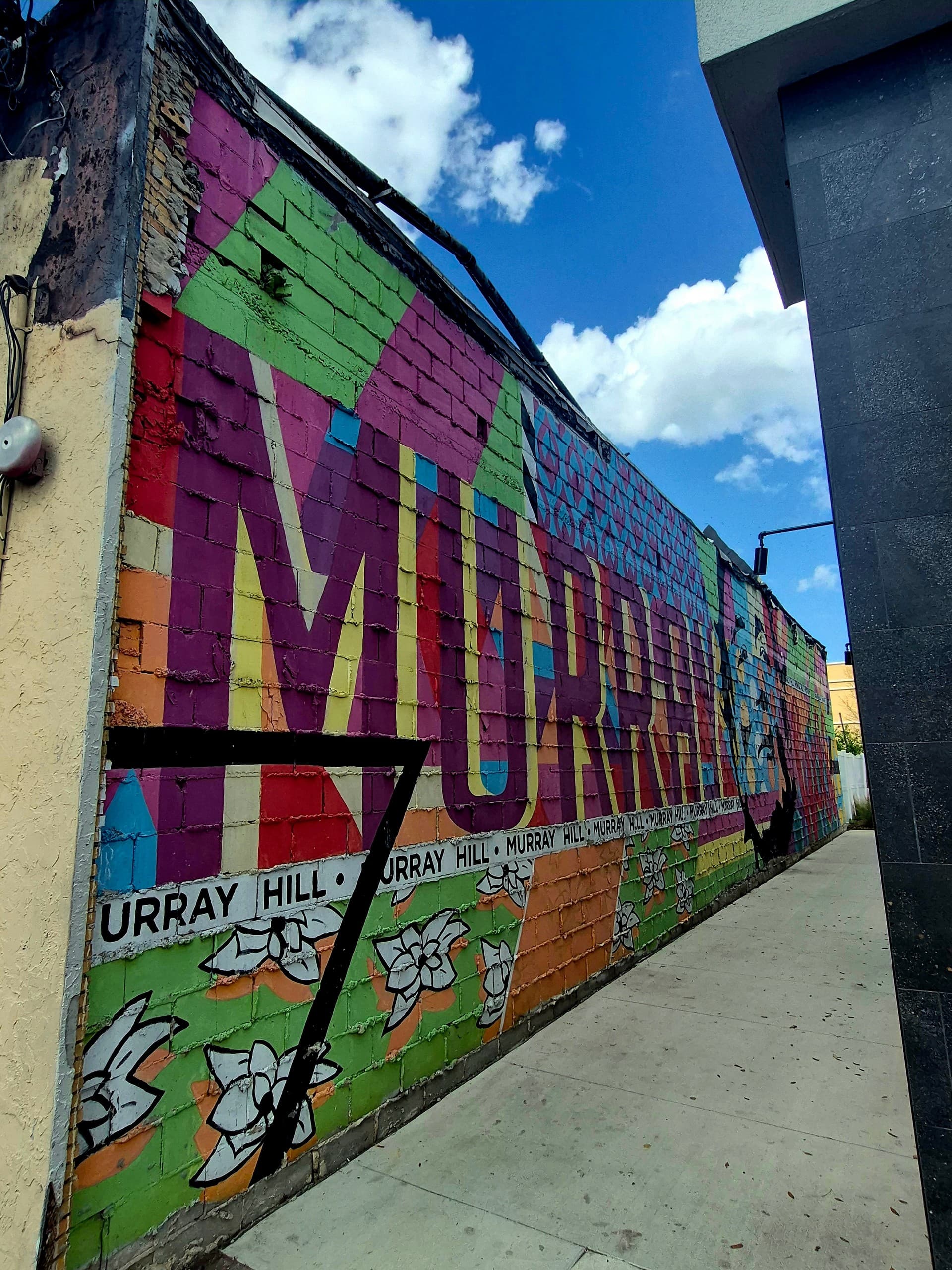 Colorful Murray Hill neighborhood mural along narrow alleyway