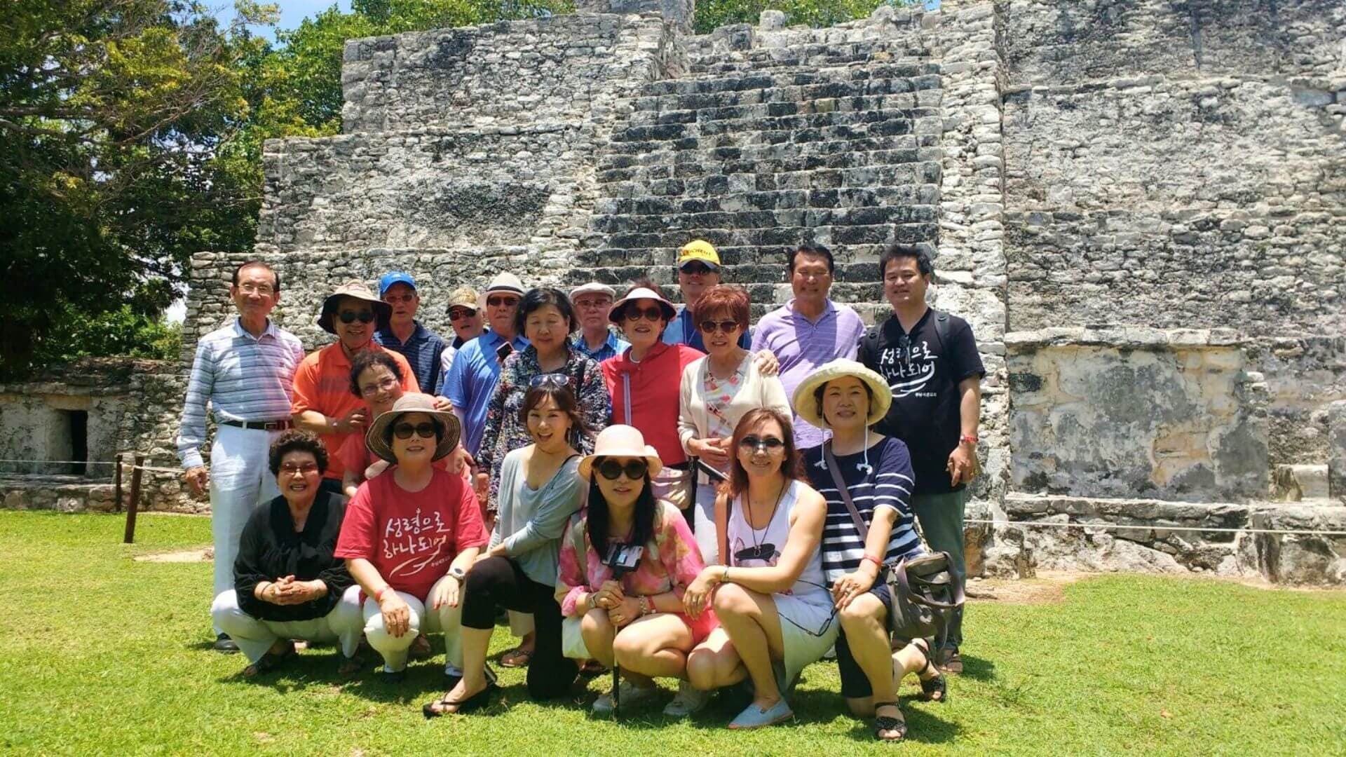 Guided group visiting ancient Mayan ruins at archaeological site