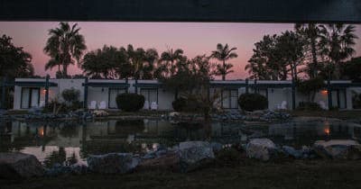 Sunset view of oceanfront villas and palm trees at resort