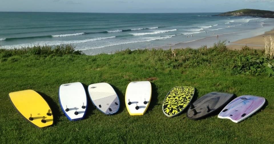 Surfboards lined on grassy dunes overlooking the ocean