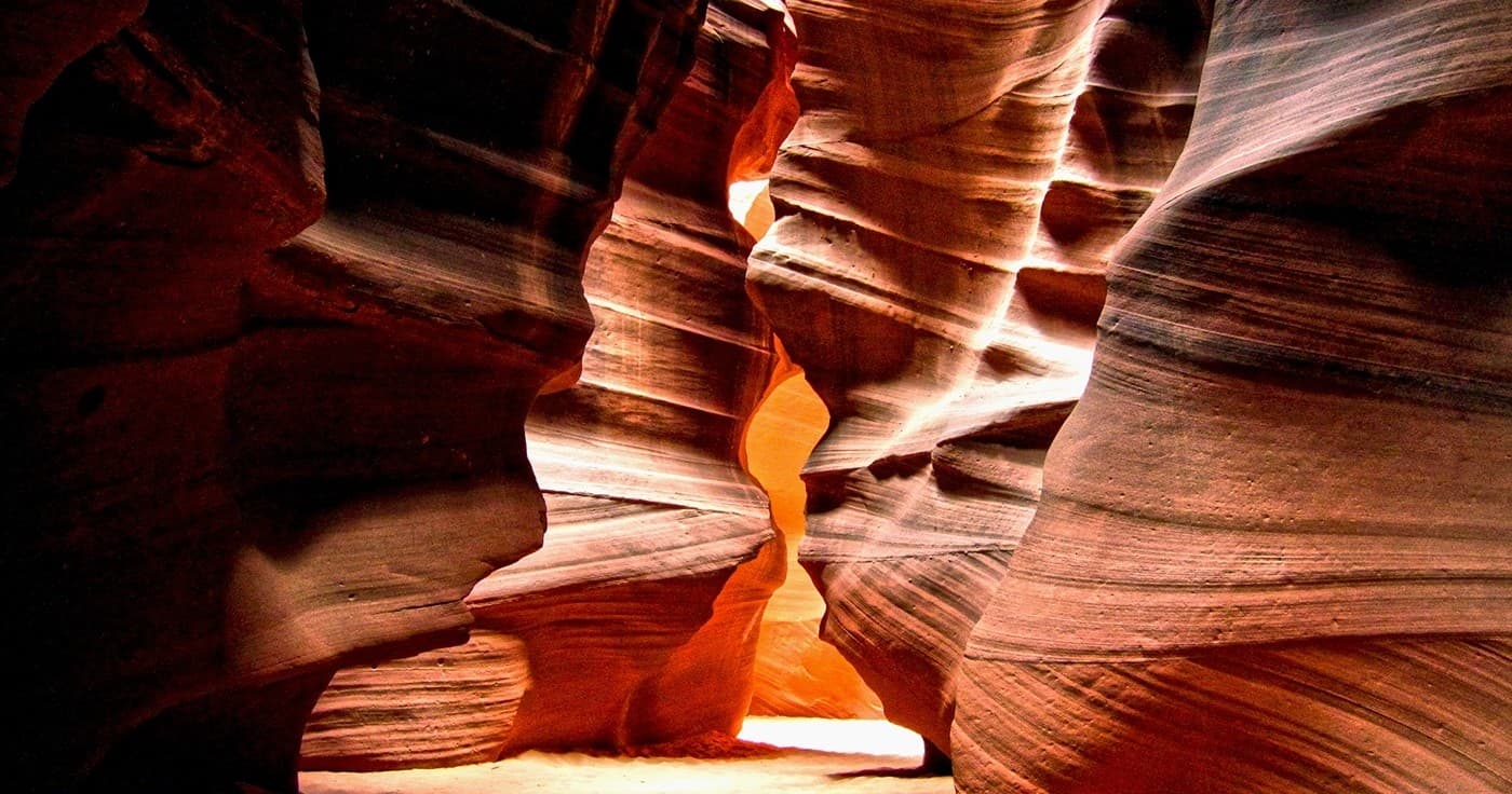 Antelope Canyon illuminated slot canyon interior with hikers passing through