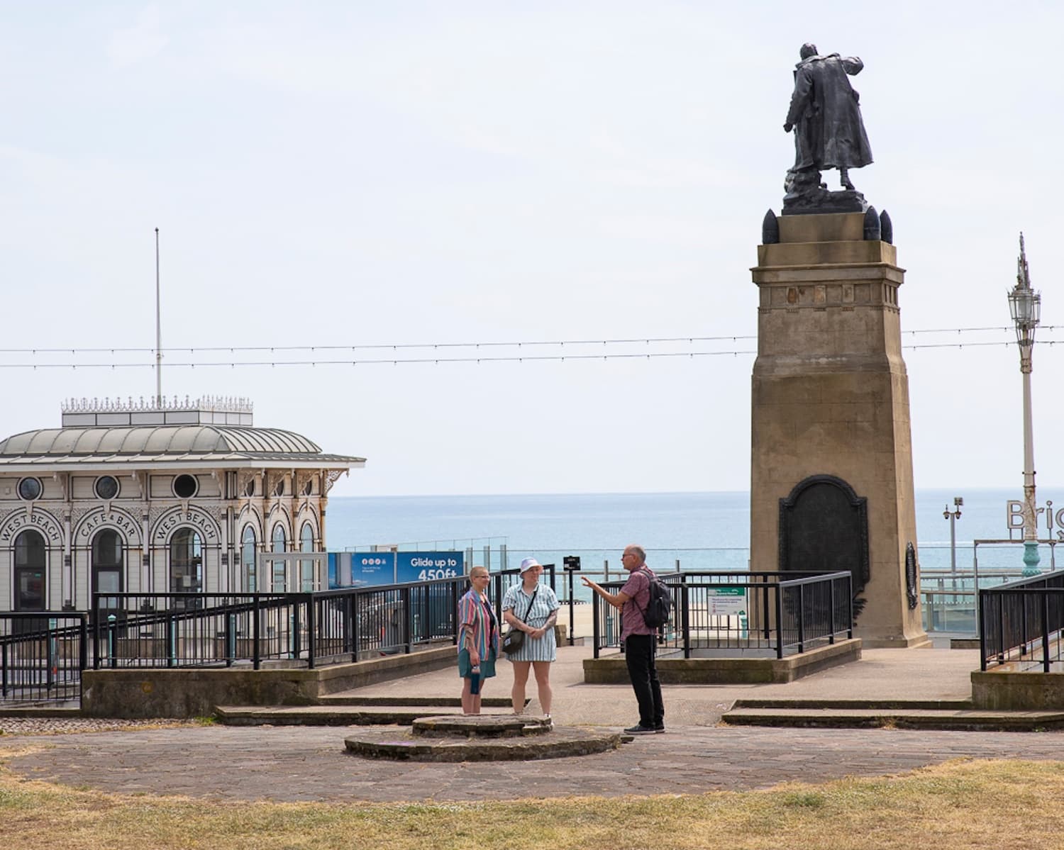 People strolling by seaside war memorial on Brighton promenade