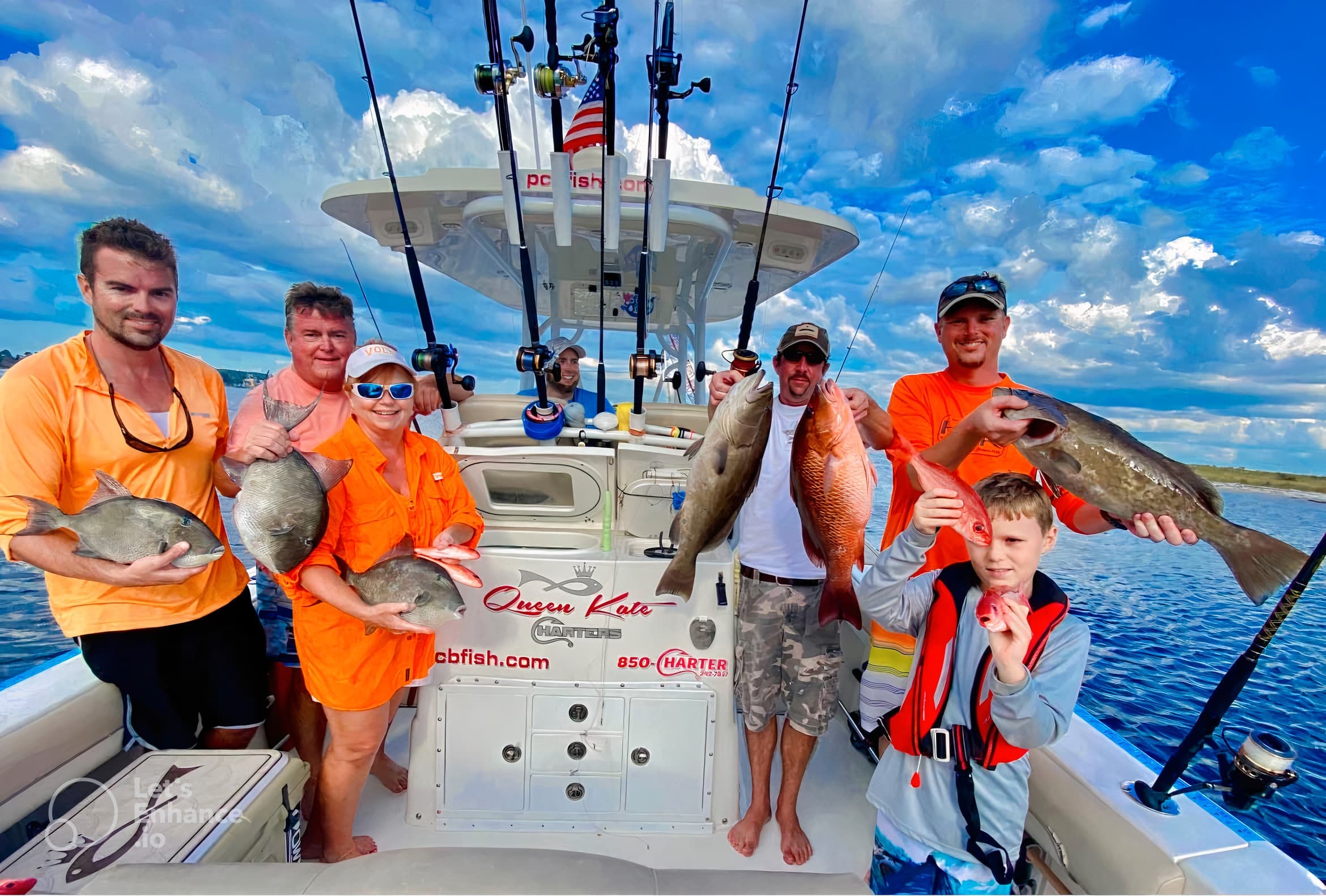 Sportfishing crew landing mixed fish on offshore boat with blue sky