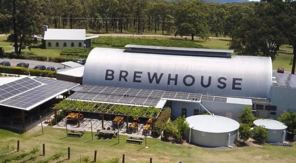 Rural brewhouse building and outdoor seating at farm brewery