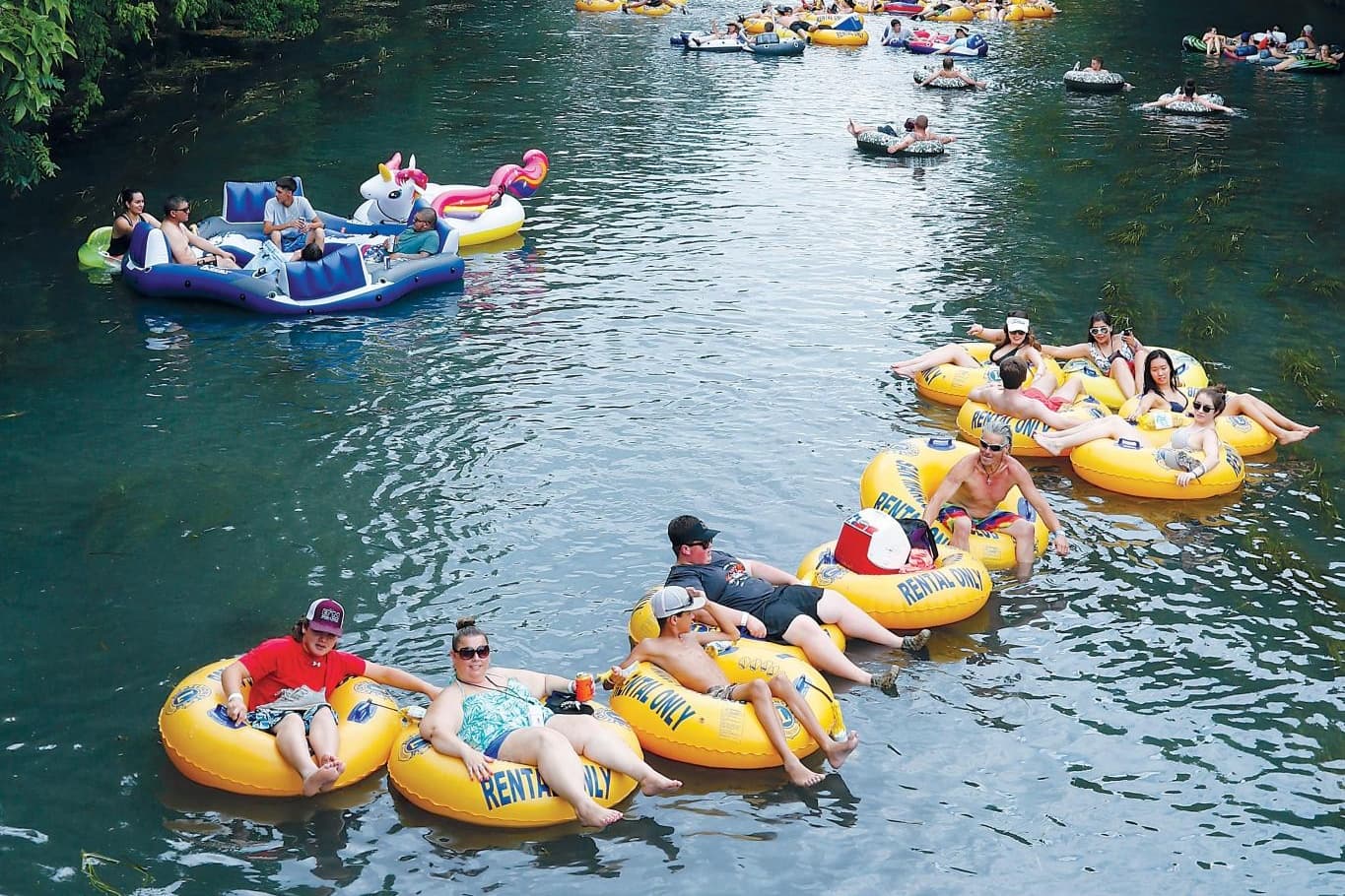 Friends tubing together down scenic clear river in Austin