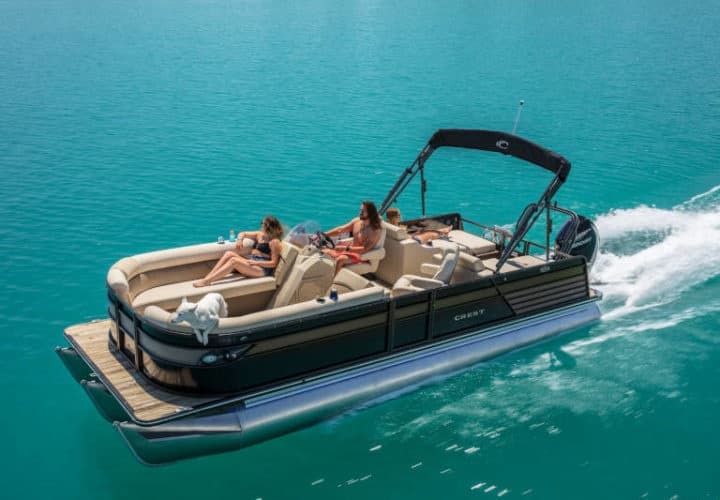 Pontoon boat cruising turquoise lake with passengers relaxing