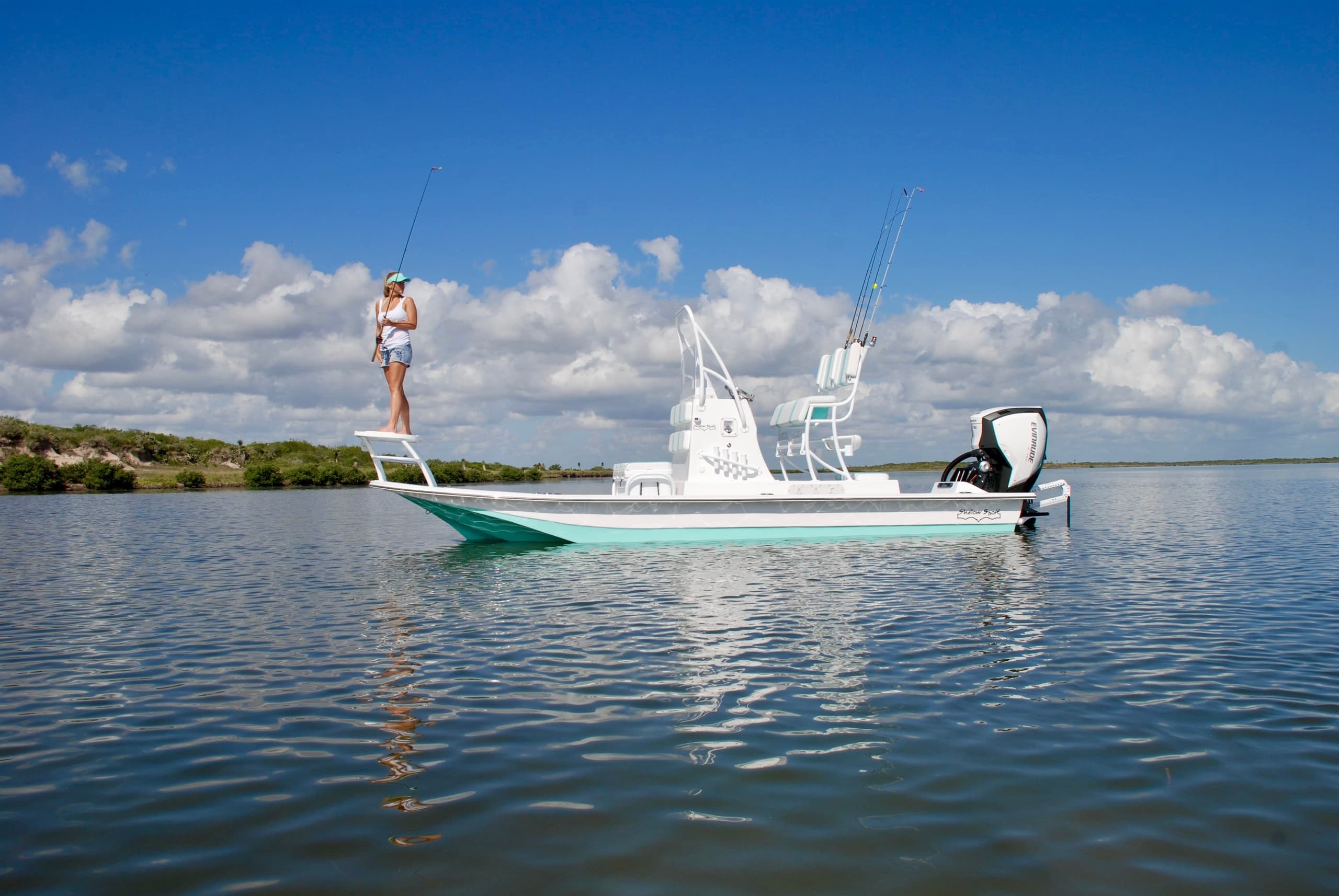 Angler standing on flats skiff in calm coastal waters