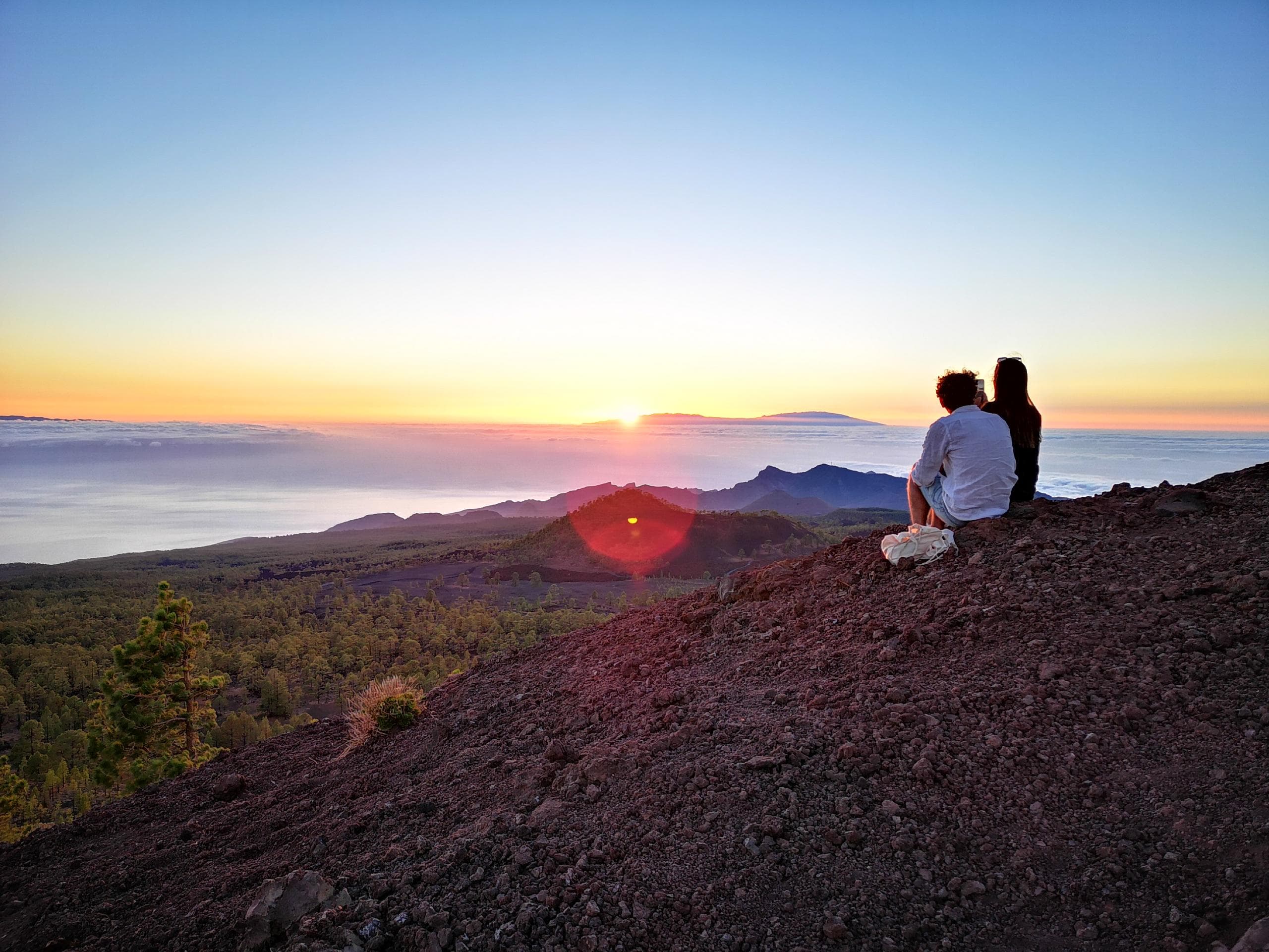 Couple watching sunset over volcanic hills in Tenerife hiking spot