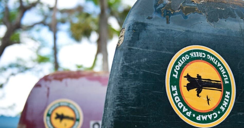 Close-up of branded canoe hulls with FishEatingCreekOutpost logo