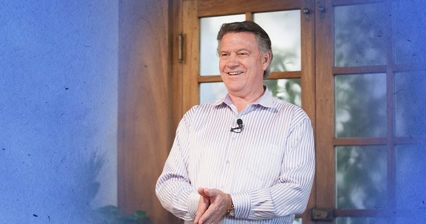 Speaker delivering a talk inside a sunlit meeting room by window