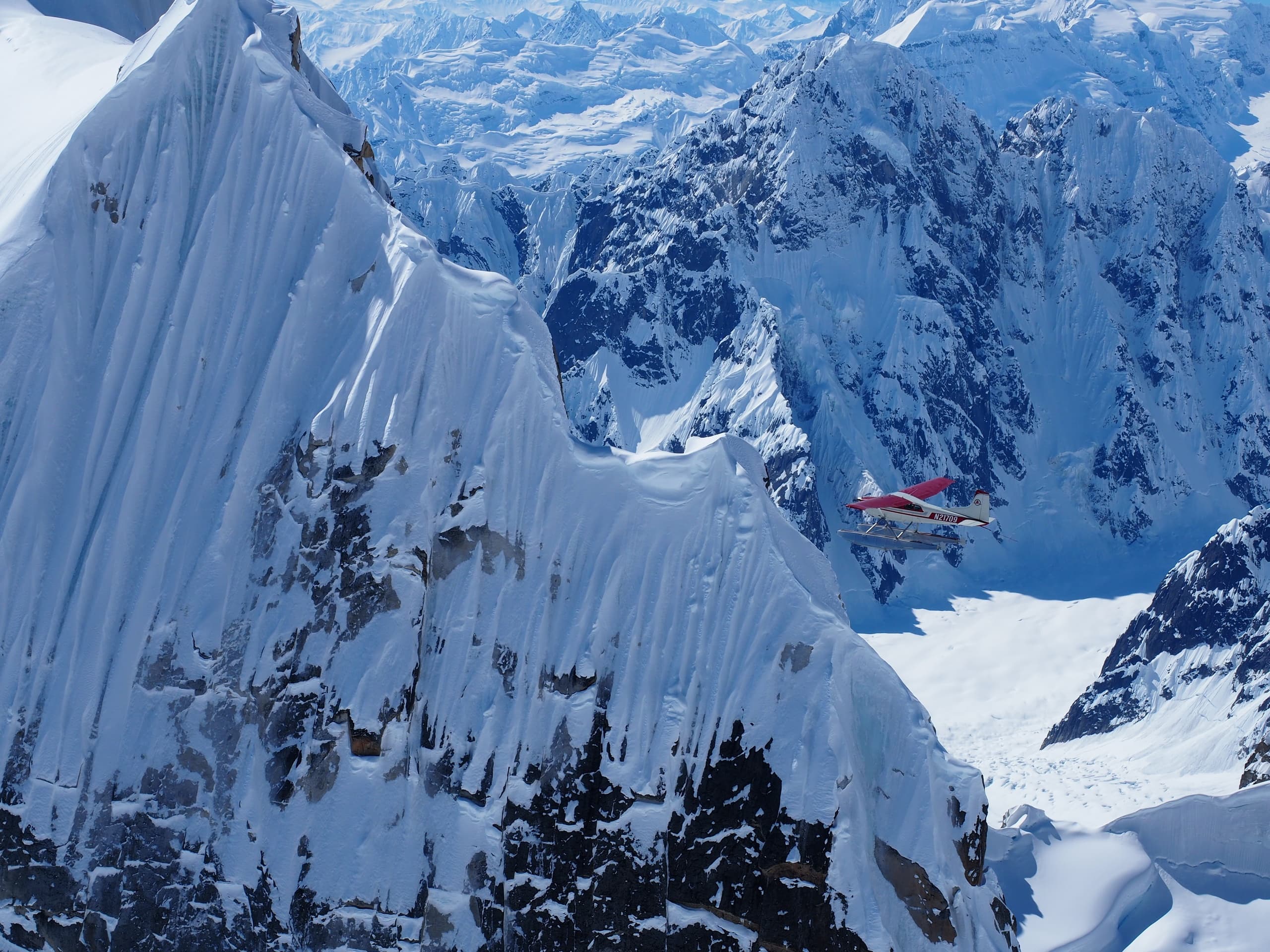 Bush plane navigating tight icy fjord and steep glacial cliffs