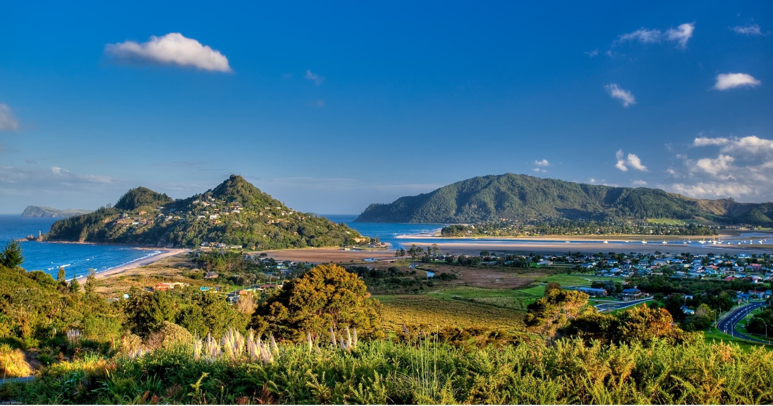Scenic island-studded coastal landscape with rolling green headlands