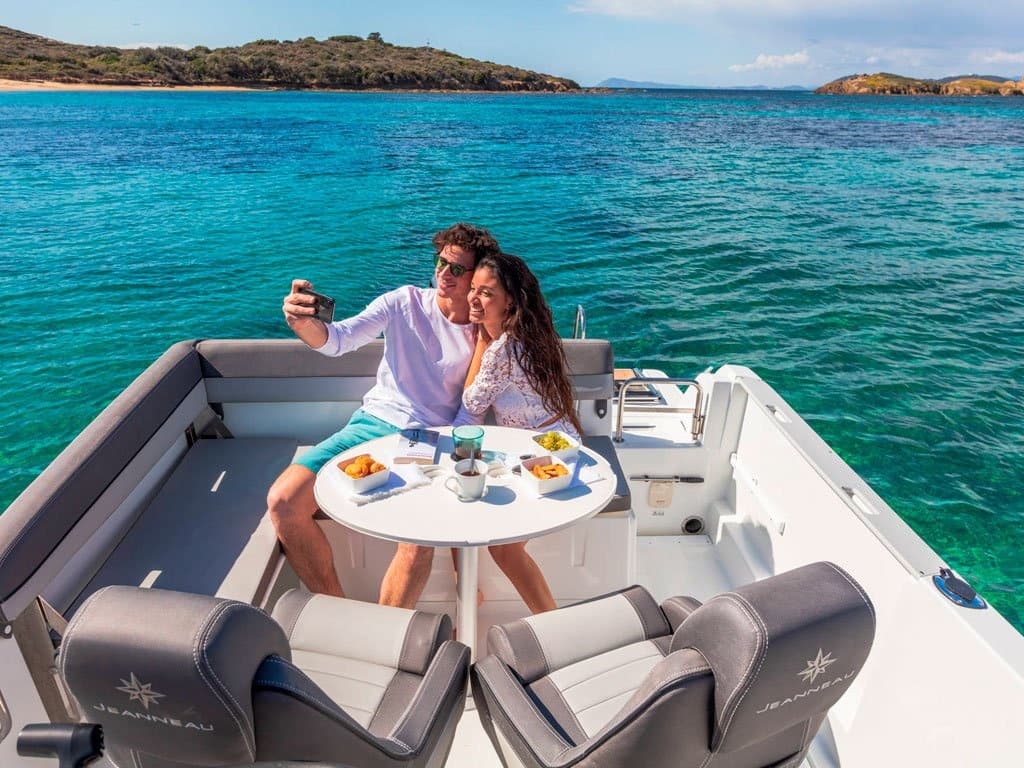 Couple enjoying boat picnic on clear turquoise Mediterranean sea
