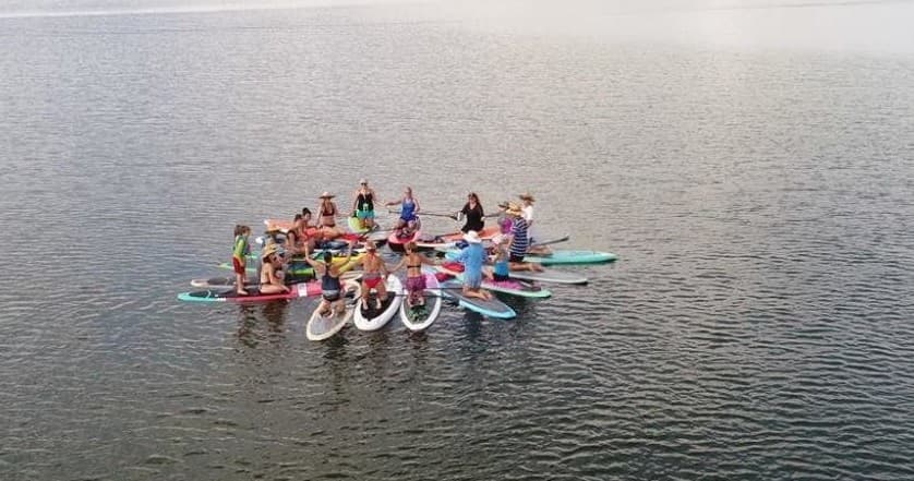 Aerial view of large paddleboard group on open lake