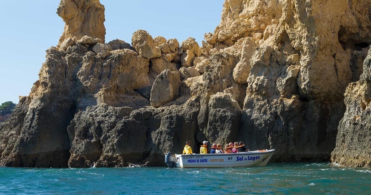 Scenic cliffside boat tour along golden rock formations