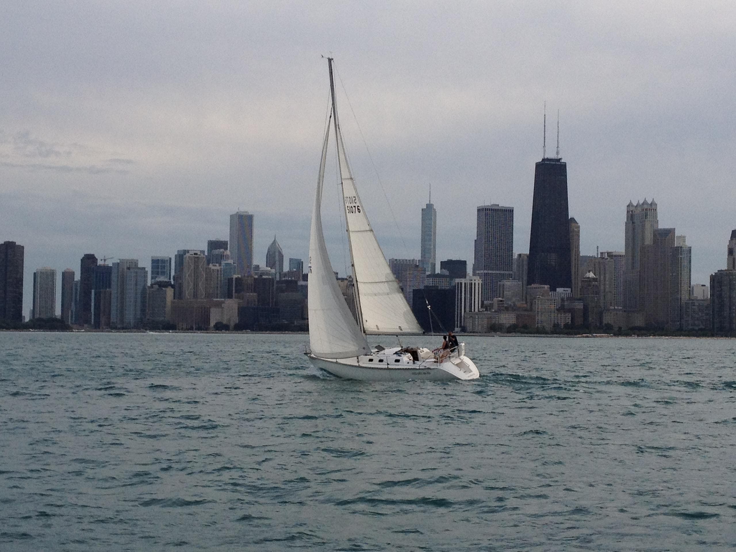 Sailboat cruising with Chicago skyline on Lake Michigan
