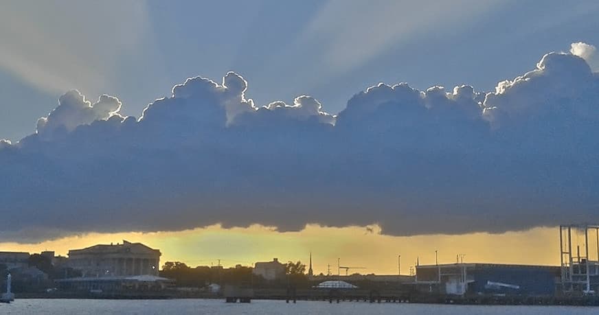 Dramatic cloud rays over Charleston harbor at golden hour