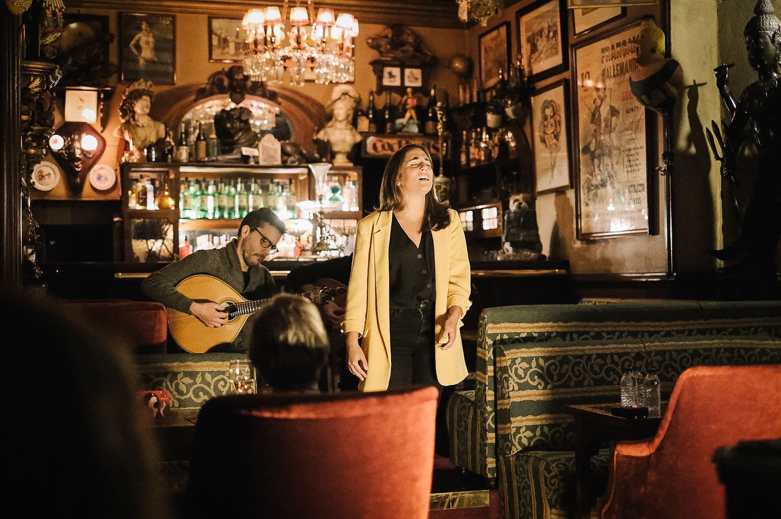 Singer performing fado in intimate dimly lit bar venue