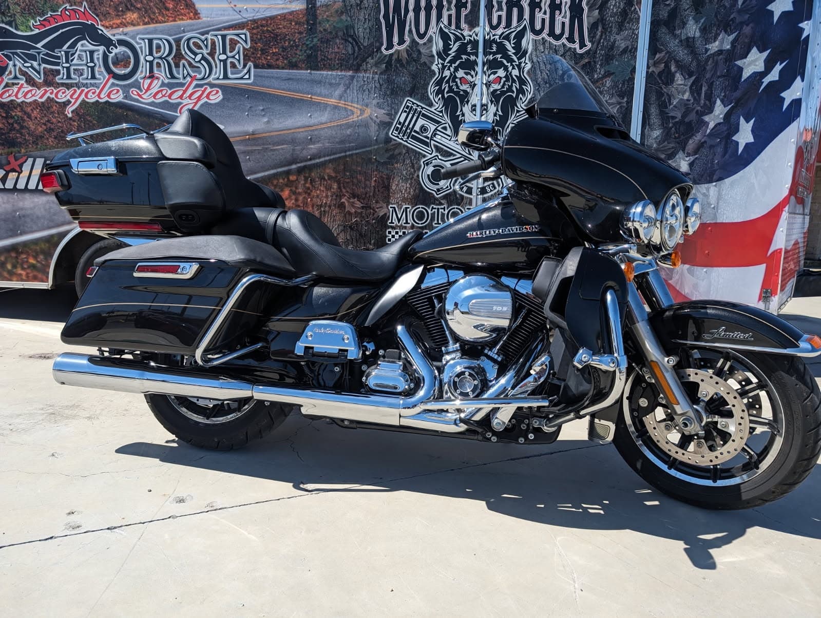 Black touring motorcycle parked outdoors by American flag