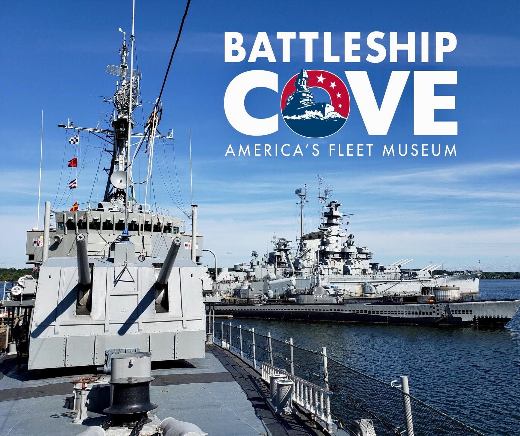 Battleship Cove docked fleet under blue sky at waterfront museum